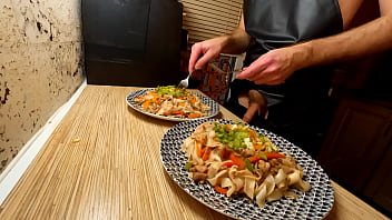 Sumptuous cooking. Nude homo chef is cooking rice noodle with chicken and vegetables